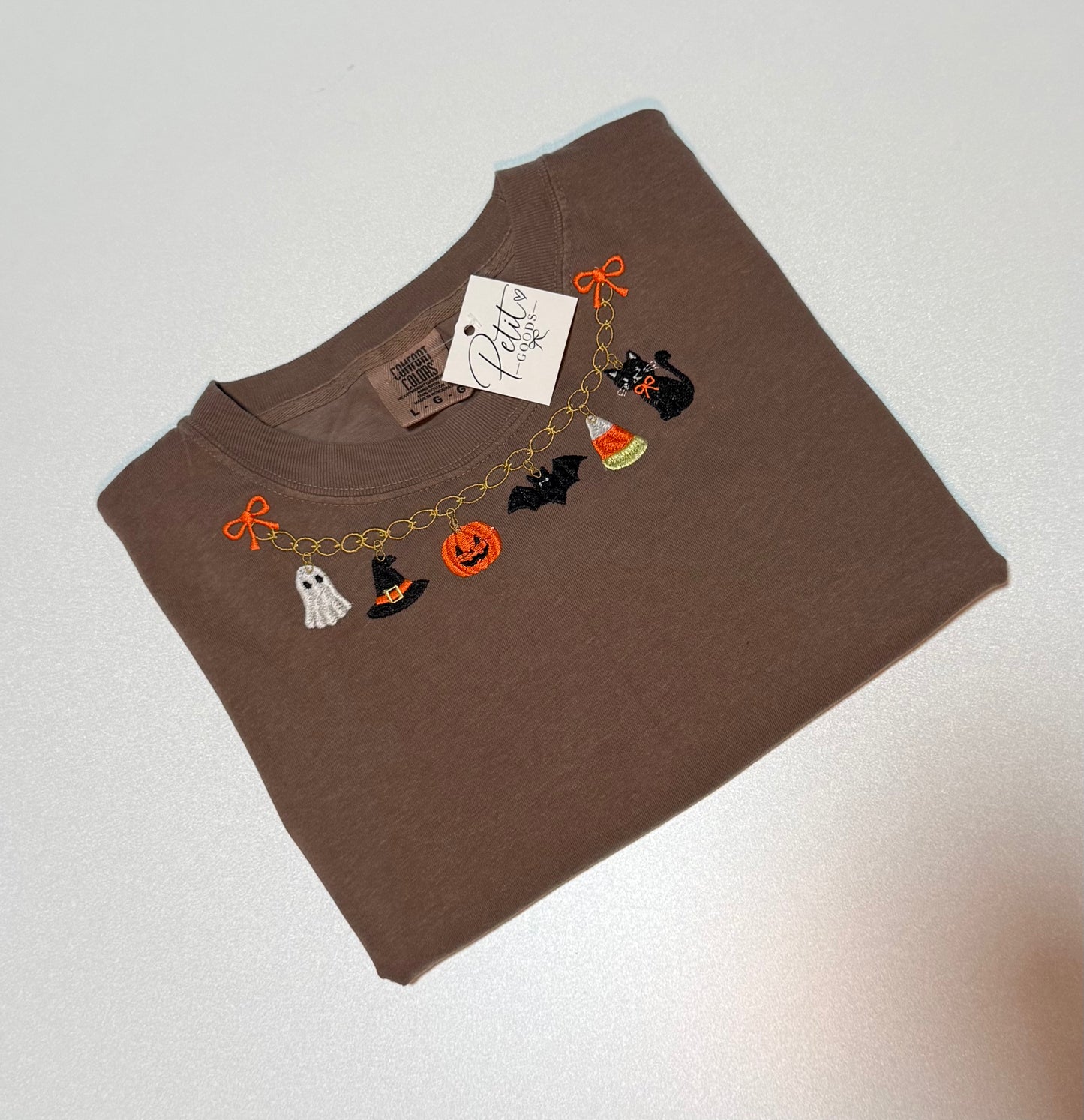 Brown embroidered tee with Halloween charm necklace design