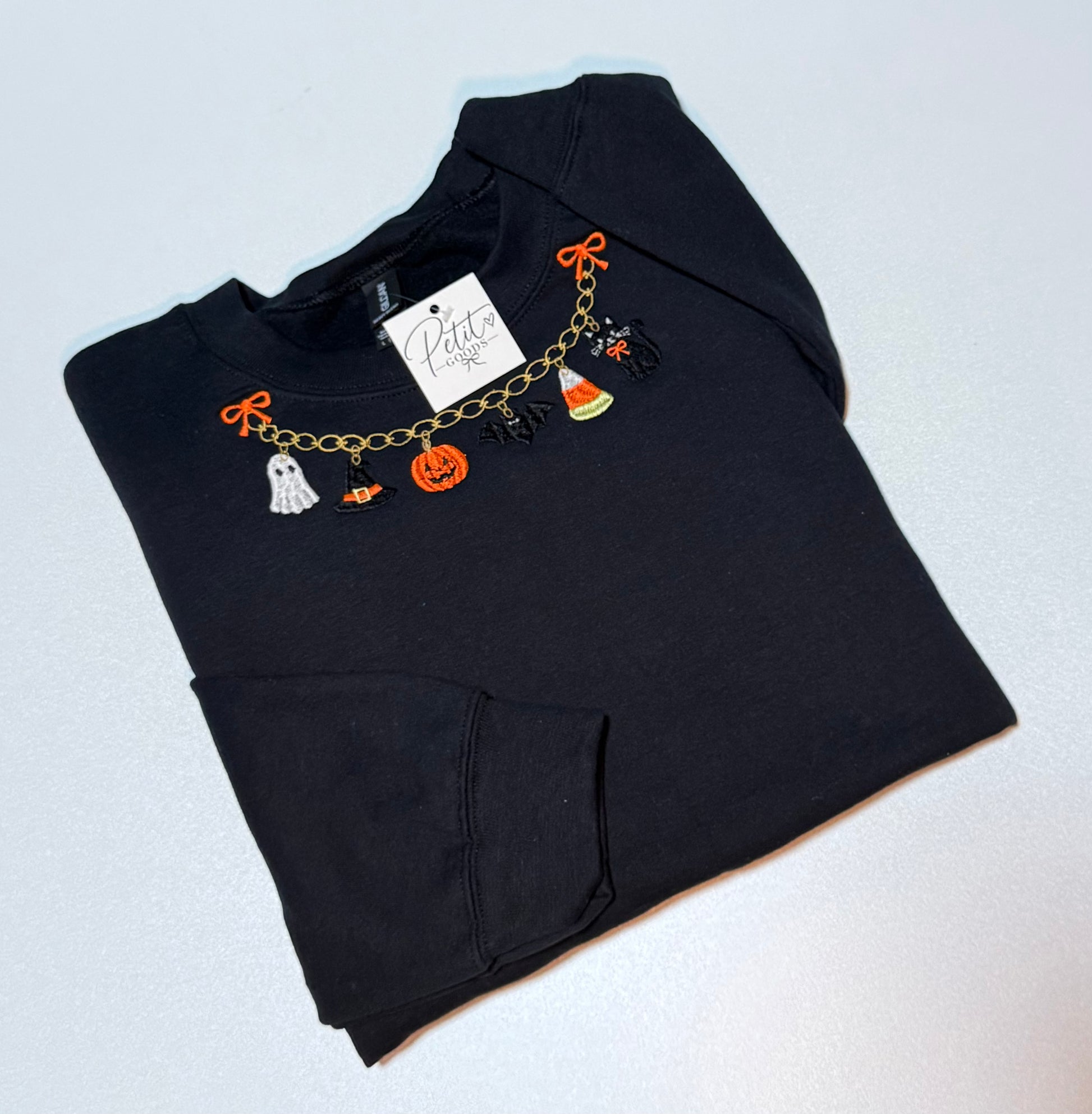 Black embroidered sweatshirt with Halloween charm necklace design