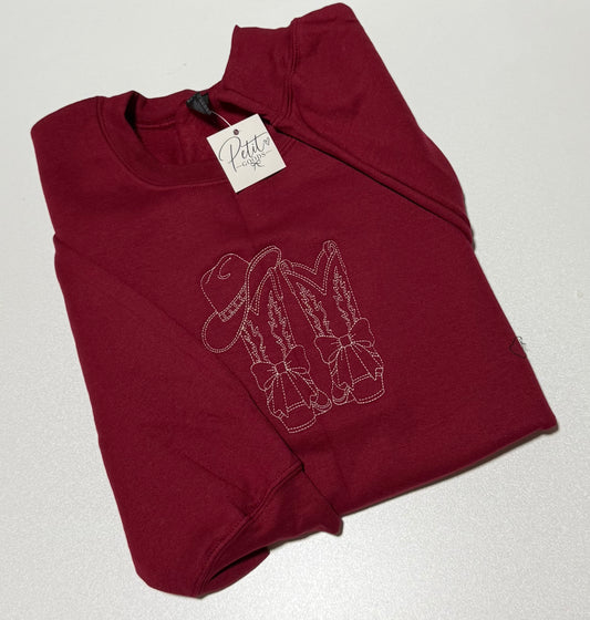 Red embroidered sweatshirt with line art cowboy boots design
