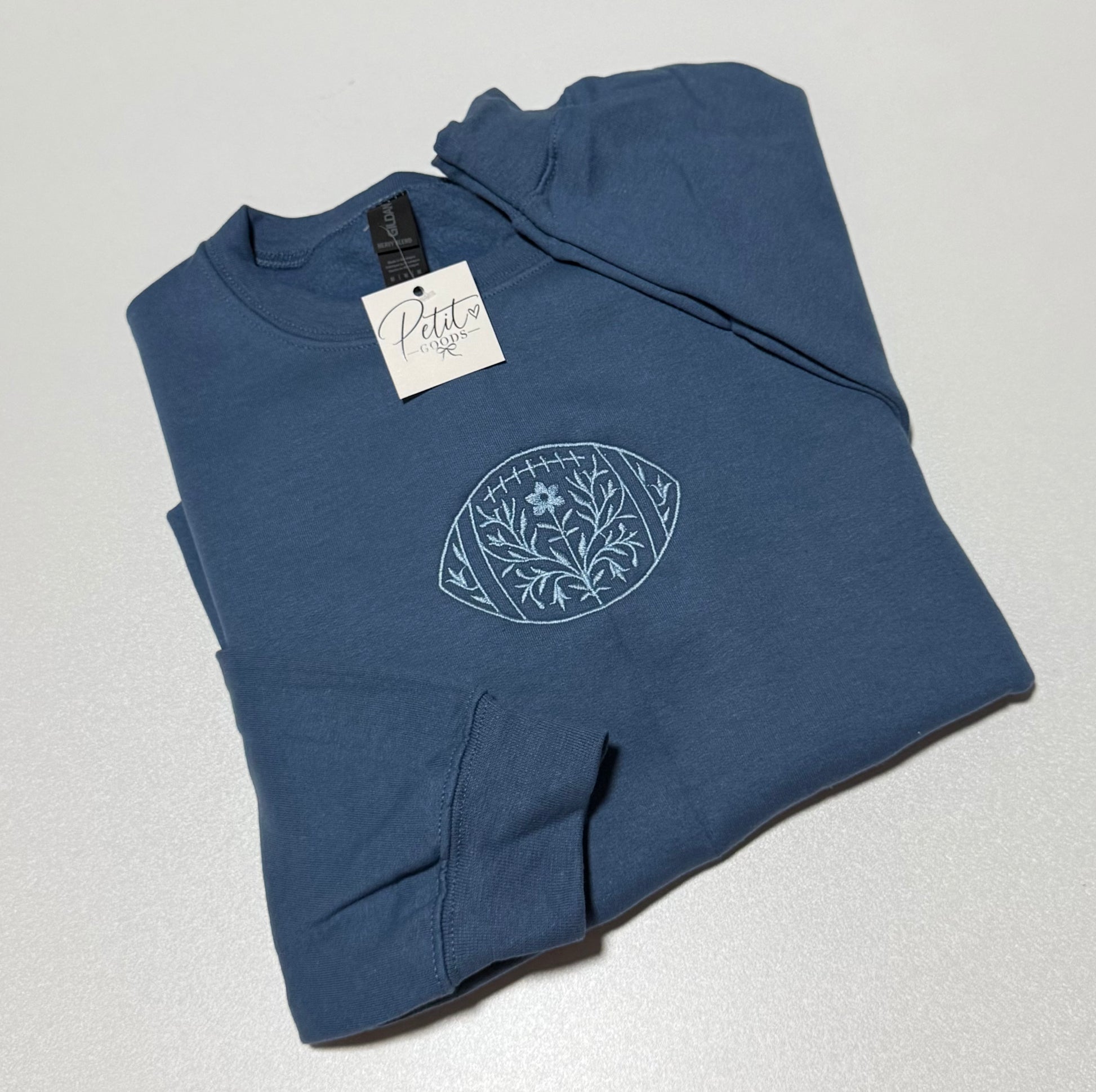 Blue embroidered sweatshirt with floral football design